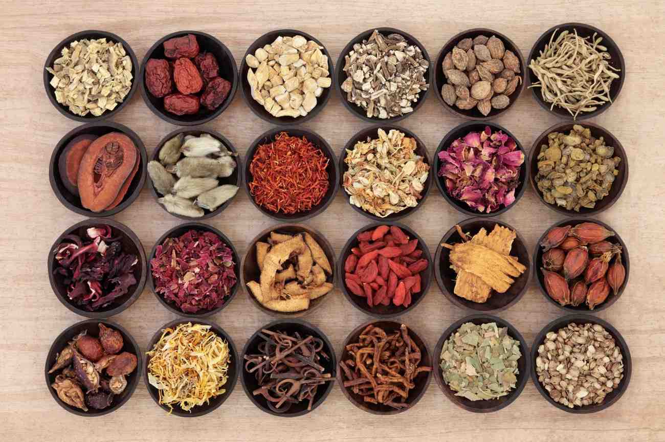Bowls of dried medicinal herbs and roots